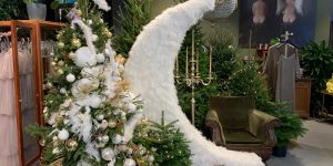 Bagātīgi dekorētu egļu kompozīcija ar svečturi, klubkrēslu un dekoratīvu pusmēnesi salonā Amoralle